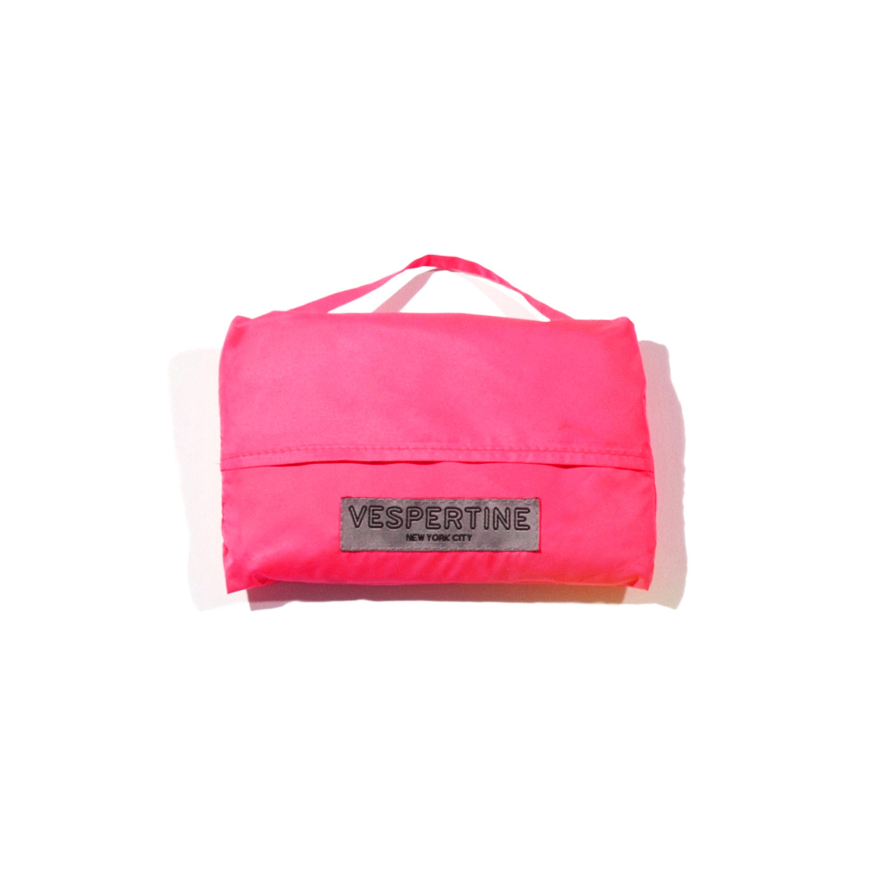 shown packed in cute pouch a vespert eco cotton candy neon pink stylish reflective hi vis safety vest for women reflecting clothing high visibility gear accessory womens fashion bike bike cycling walk run running dog walking walker night sustainable nighttime bright 3M scotchlite made in NYC USA designed to be seen  packable